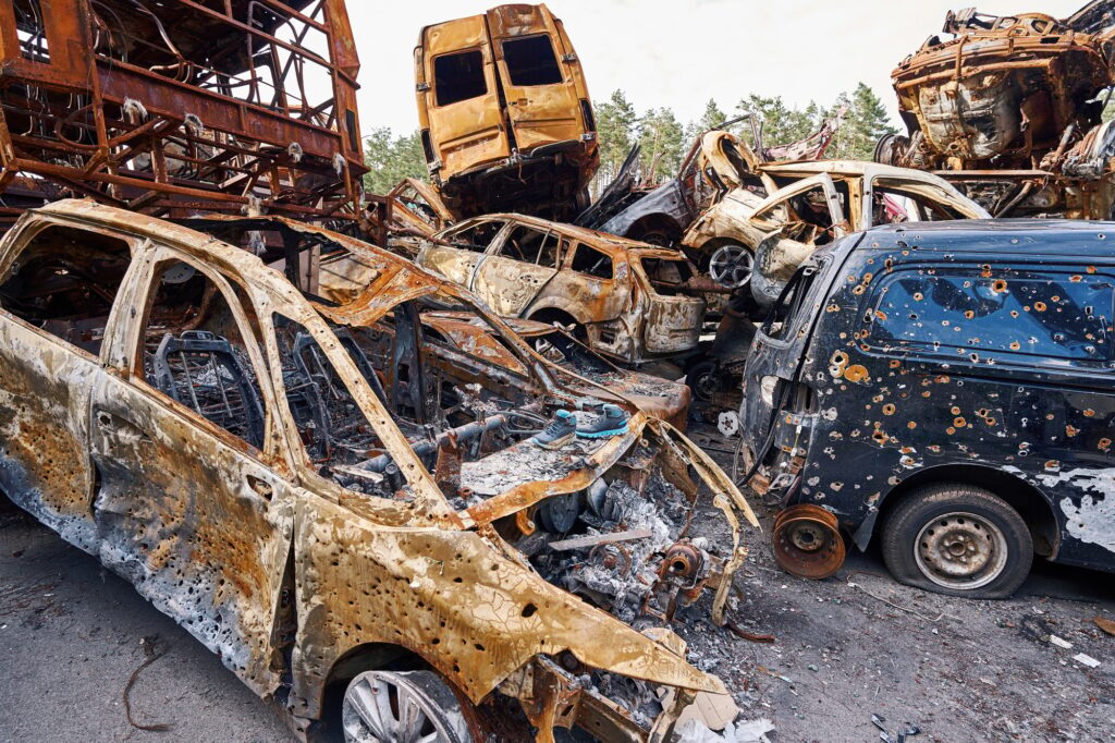 Civilian vehicles with bullet holes lying on junkyard